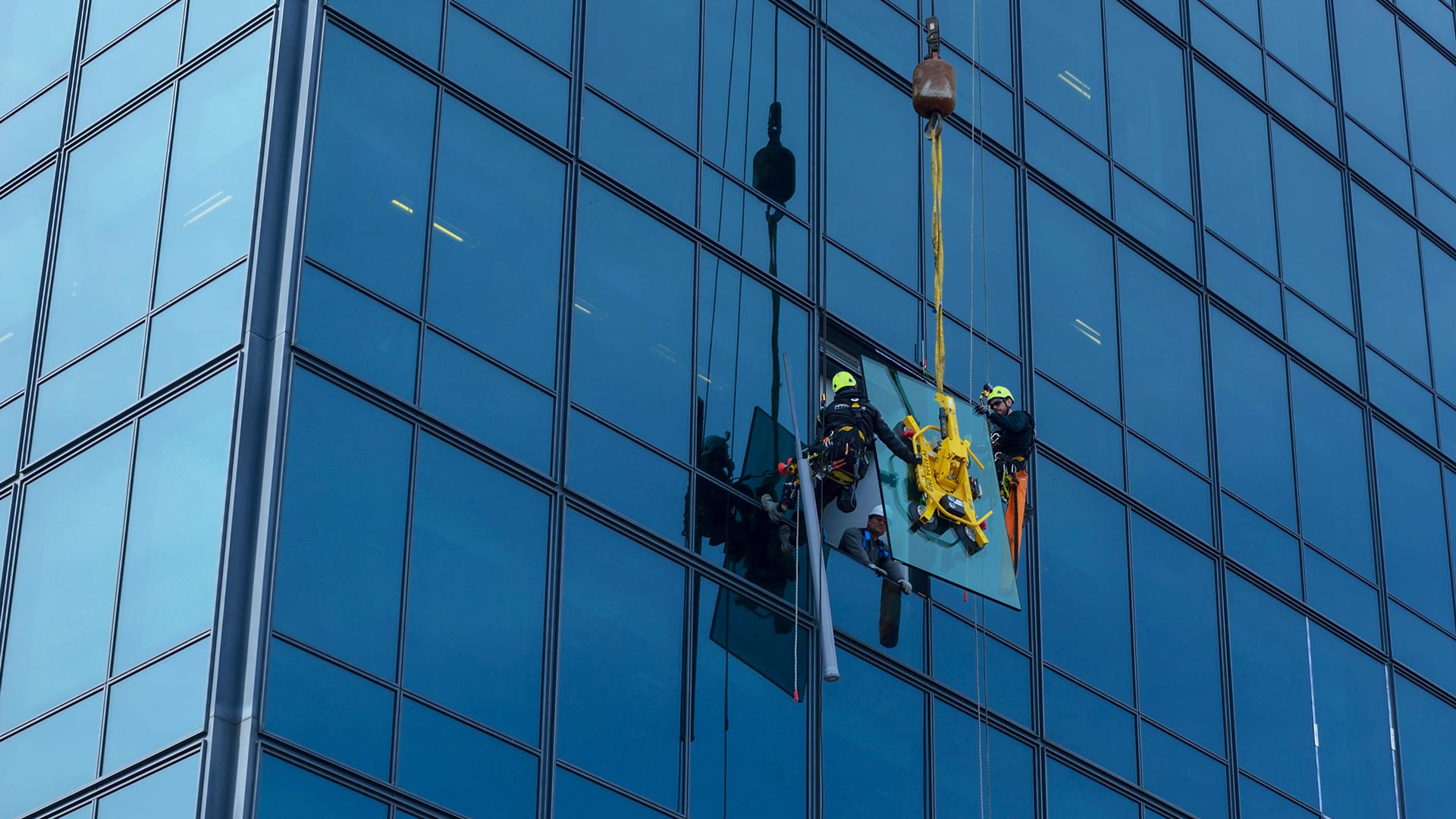 Installer fitting energy-efficient replacement window in older Steilacoom home with waterfront exposure, Skilled window contractor inspecting frame condition and seal placement before installation