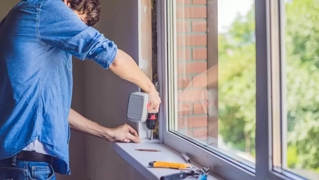 Contractor installing replacement window in coastal home living room, Window professional checking frame alignment and seal integrity with specialized installation tools, Installer checking window frame alignment and weather sealing with precision tools, Skilled technician adjusting window hardware and checking frame alignment indoors