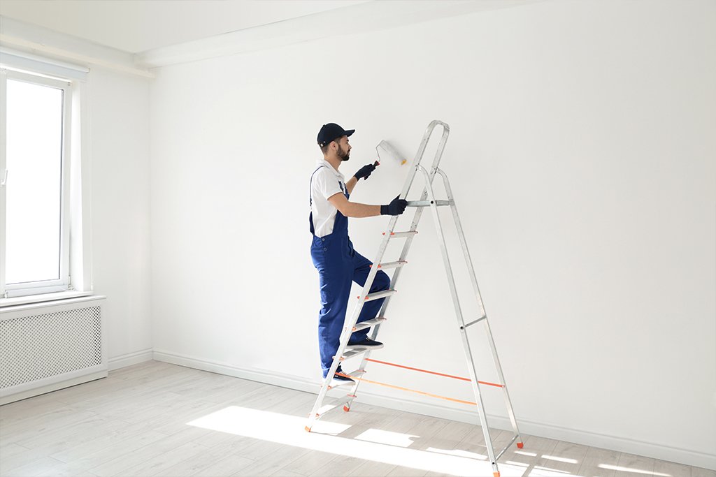 Contractor installing replacement window in coastal home living room